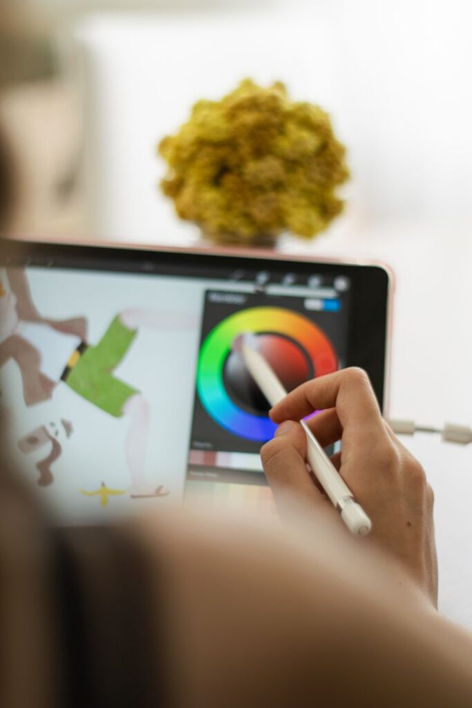 Close-up of a hand using a stylus on a digital drawing tablet for art creation.